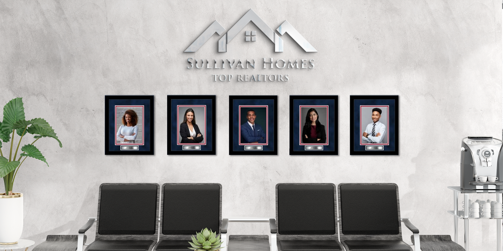 Real estate office with custom framed headshots of top realtors hanging on wall in lobby