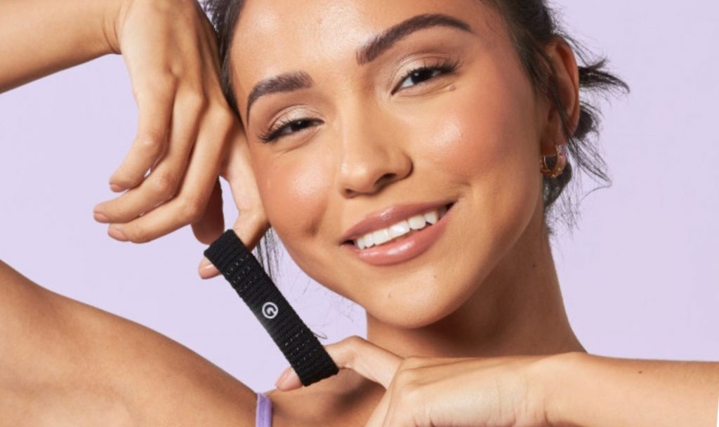 Closeup of smiling woman pulling black hair band with fingers