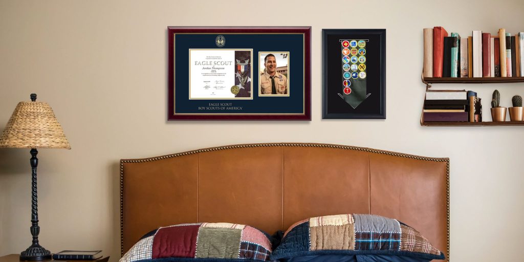 Scouting America certificate and photo frame and sash shadow box on wall above bed in bedroom
