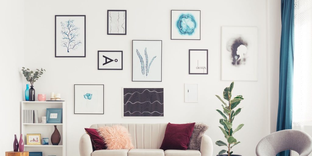 living room with gallery wall of hung art above couch with pillows