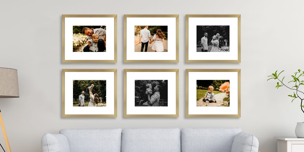 six custom frames with white mats and family photos in a grid layout hung above a couch