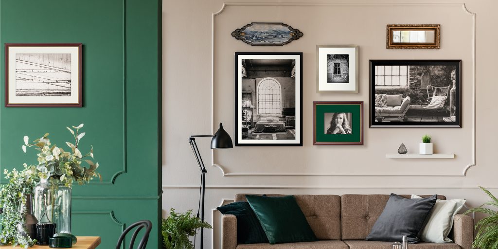 organic gallery wall display with various custom frame styles and artwork hung in sitting room