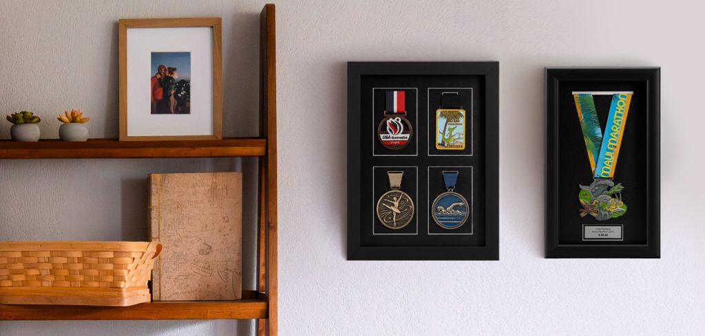Marathon multi-medal shadow box and marathon medal frame with engraved nameplate on wall next to bookshelf.
