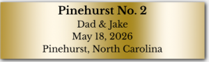 Gold nameplate that says "Pinehurst No. 2, Dad & Jake, May 18, 2026, Pinehurst, North Carolina."